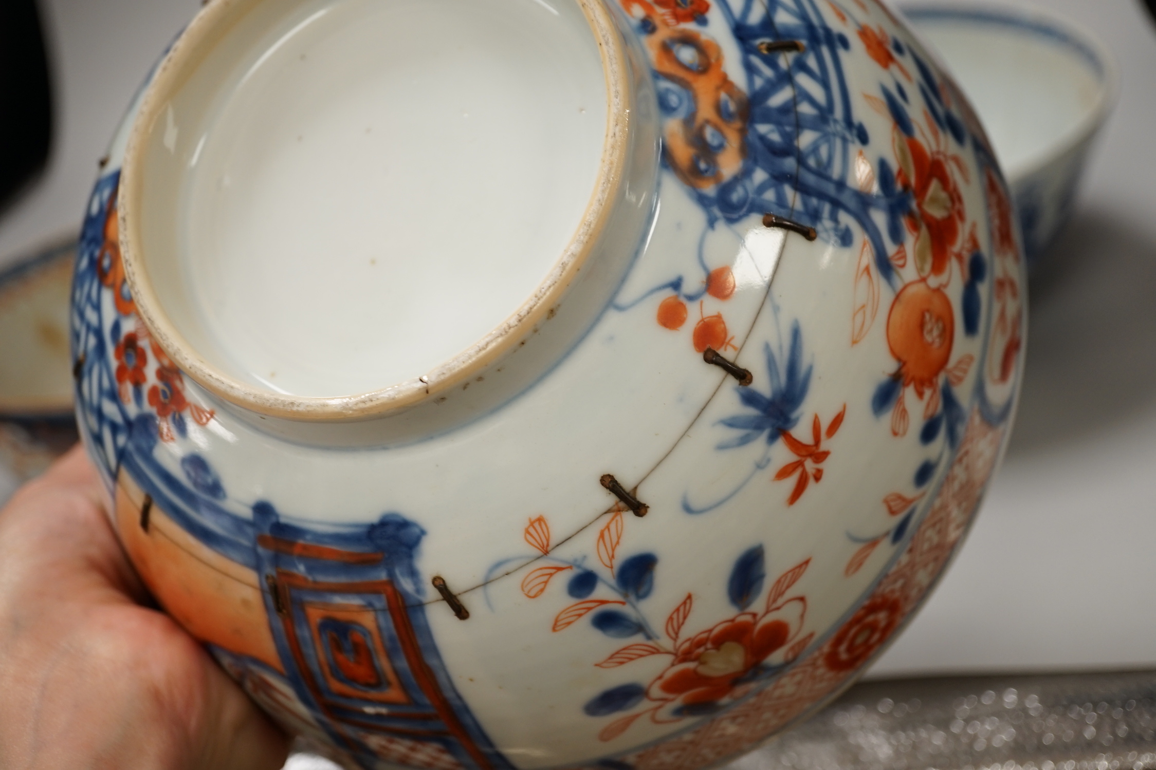 Four 18th century Chinese porcelain bowls (a.f), one with hardwood stand, largest 28cm diameter